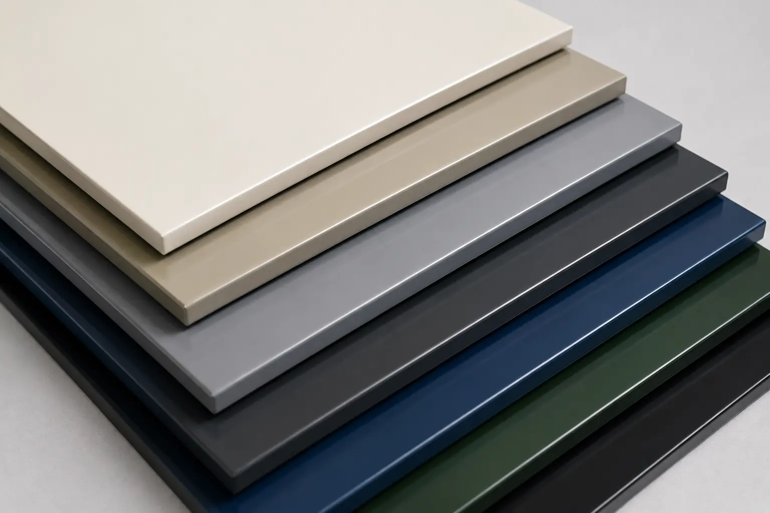 A fan of PVDF architectural finish samples across a colour range &mdash; beige, grey, navy, green and black &mdash; shown here on rigid panels